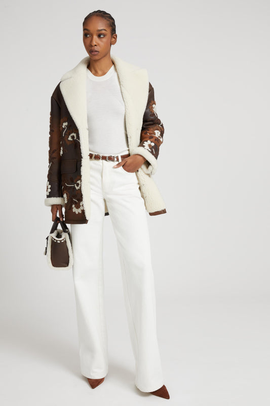 Palazzo trousers in white denim with floral cut-out