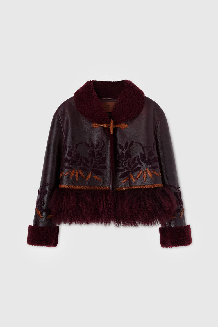 Short single-breasted shearling with handmade embroidery and fur on the bottom