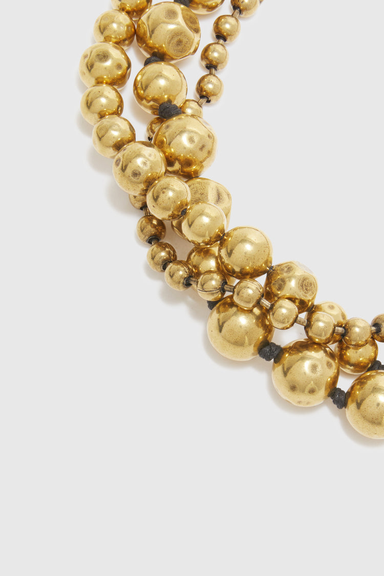 Three-strand necklace of gold metal pearls