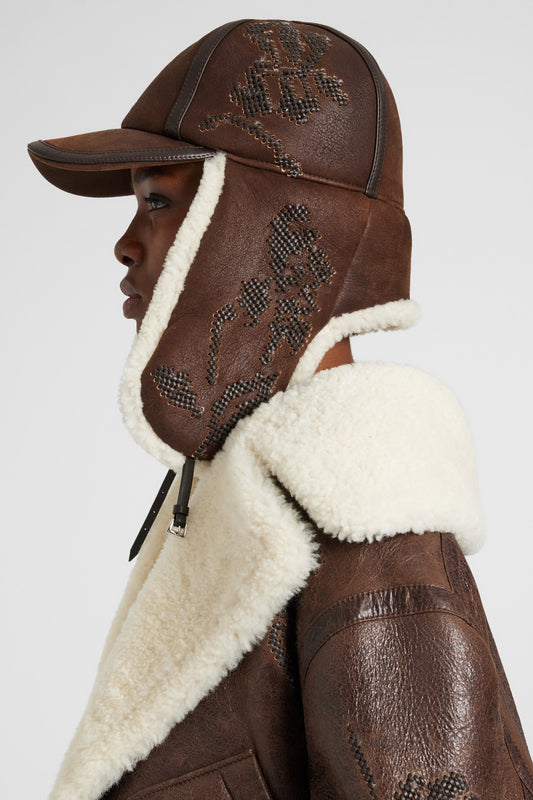 Embroidered baseball-style hat with shearling ear flaps