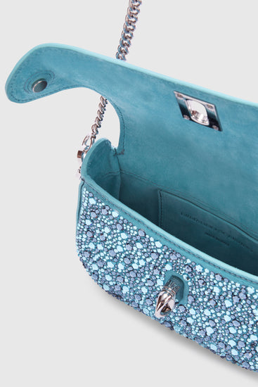 Interno aperto di una borsa azzurra scintillante con catena argento, mostrando l'ampio scomparto e la fodera. Prospettiva laterale da destra
