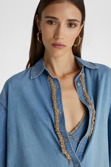 Close up of model in Oversized Denim Button-up shirt featuring gold chain piping