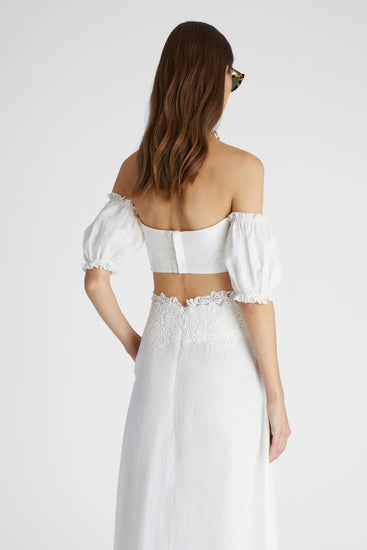 Rear view of model in white linen crop top with balloon sleeves and cotton macramé lace inlay