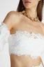 Close-up of model in white linen crop top with balloon sleeves and cotton macramé lace inlay