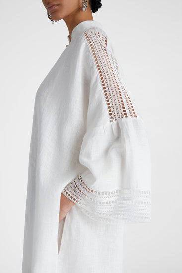 Close up of model's side profile showcasing pure linen White Kaftan with cap sleeves and embroidery
