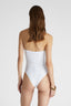 Rear view of model in white one-piece swimsuit with removable straps and irregular handmade drapes