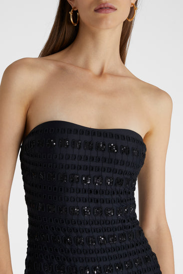Close-up of model in black one-piece macramé swimsuit with removable straps and a sequin ribbon.