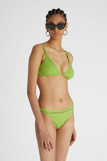 Model in green two-piece broaderie anglaise bikini consisting of briefs and triangle brassiere